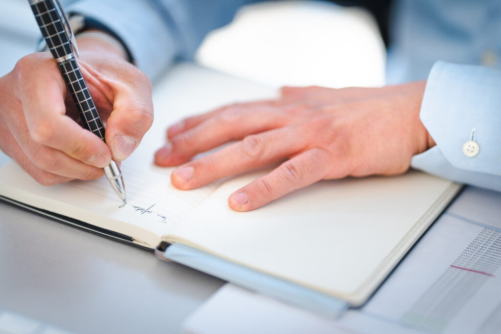 Homme écrivant sur un cahier